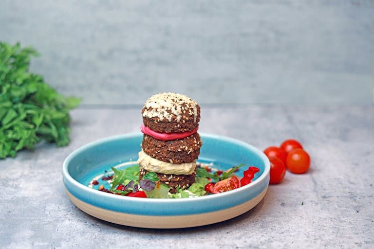 A deliciously stacked falafel with veggies on a rustic plate, perfect for a healthy brunch.