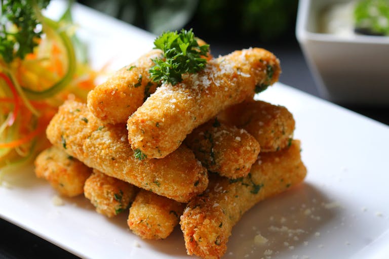 Delicious golden breaded fish sticks topped with parsley, perfect for a meal.